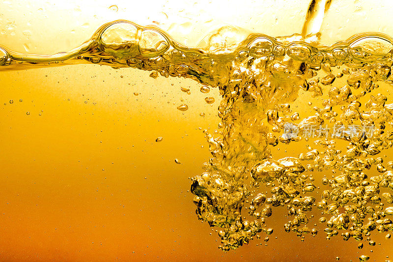 泡泡在水油啤酒黄金美丽的抽象背景