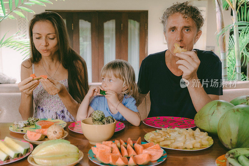 一家人在院子里吃热带水果