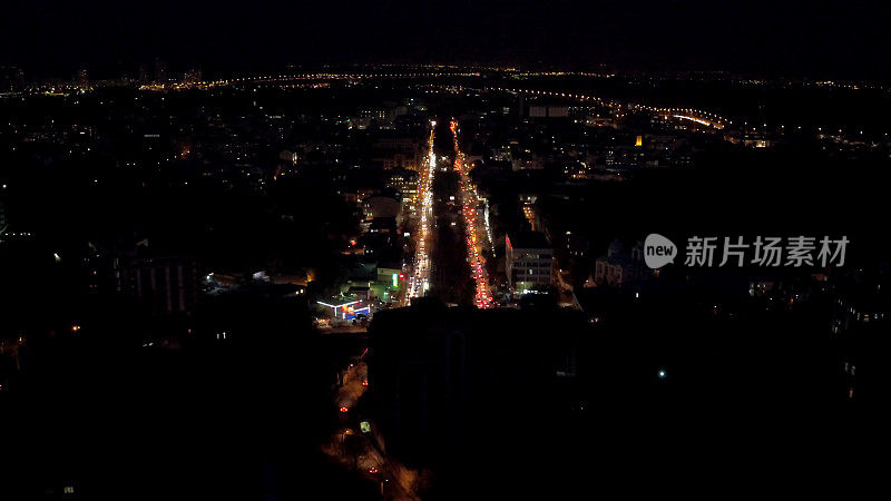 空中拍摄夜间城市，屋顶，街道，夜间交通与灯光