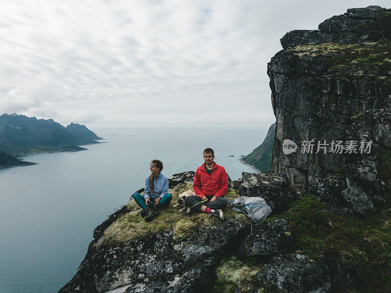 鸟瞰图，男人，女人和狗坐在挪威北部的塞格拉山顶