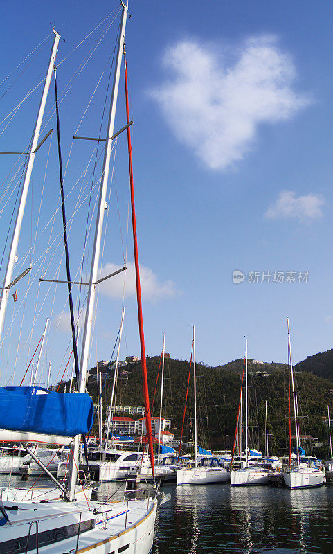 在英属维尔京群岛，有心云的田园诗般的天堂帆船港口。