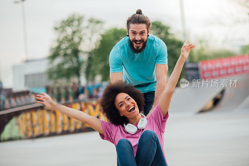 当年轻男子在滑板上推她的时候，女人举起手臂