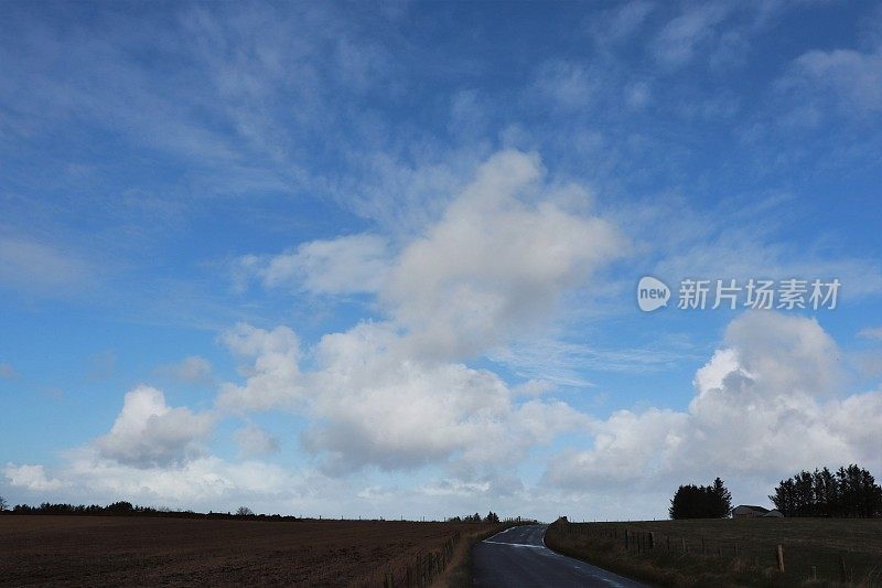 蓝蓝的天空和乡间小路上飘着朵朵白云