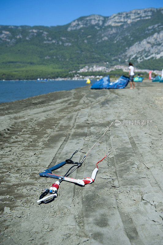 沙滩上的风筝冲浪者为骑行准备运动器材