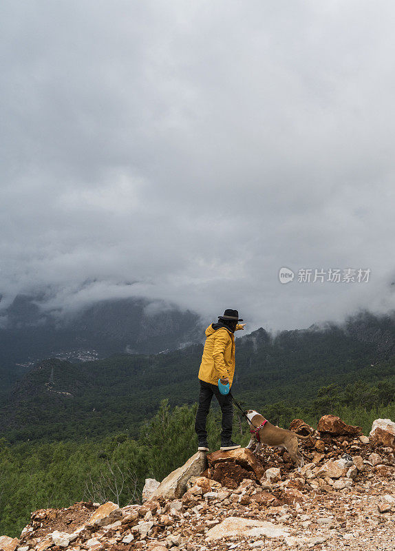 带着狗在山上徒步旅行的人