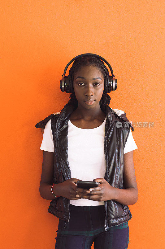 非洲裔澳大利亚少女戴着耳机听音乐