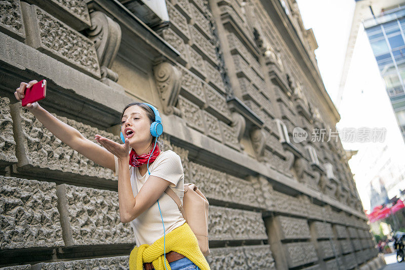 街上的年轻女子正在听音乐和跳舞