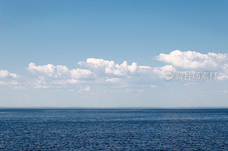 平静的海在蓝天与云的背景上平静的海与蓝天与云。海洋元素的和谐。海景。本空间