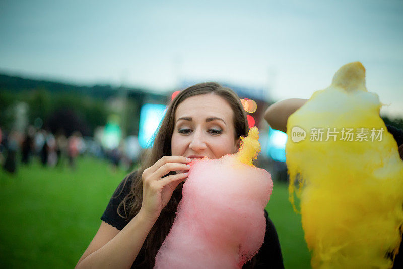 一个在音乐节上吃糖羊毛的女人