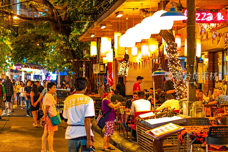 曼谷市的街头市场，有街头小吃、酒吧和商店。夜景，人们走在路上，购买食物，鸡肉饭或油炸昆虫。