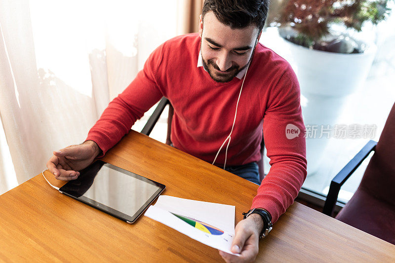 男人坐在café，用平板电脑工作