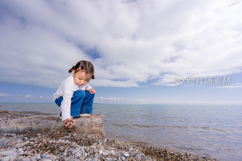 一个小女孩在湖边玩耍