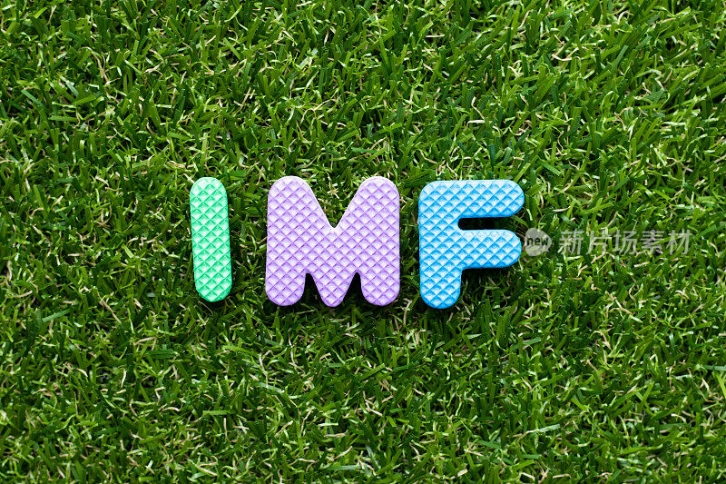 玩具泡沫字母在单词IMF(国际货币基金组织的缩写)上以绿草为背景
