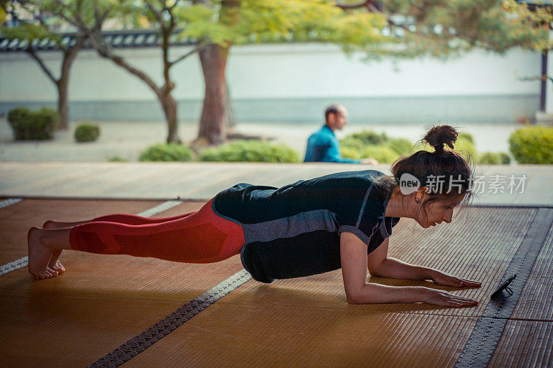 白人女性喜欢在寺庙里用智能手机练瑜伽