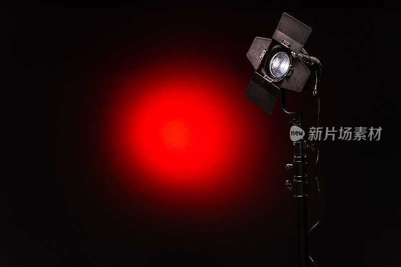 LED聚光灯与菲涅尔镜头黑色和红色背景特写