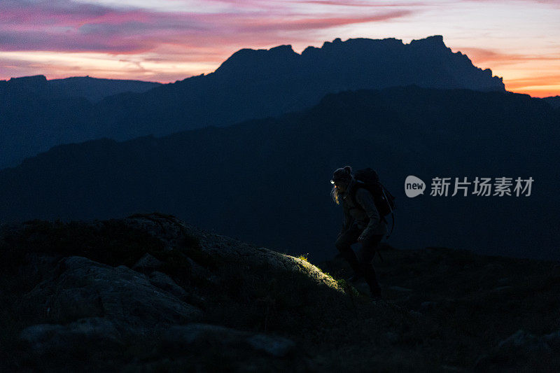 日出时，女徒步旅行者穿过山脊