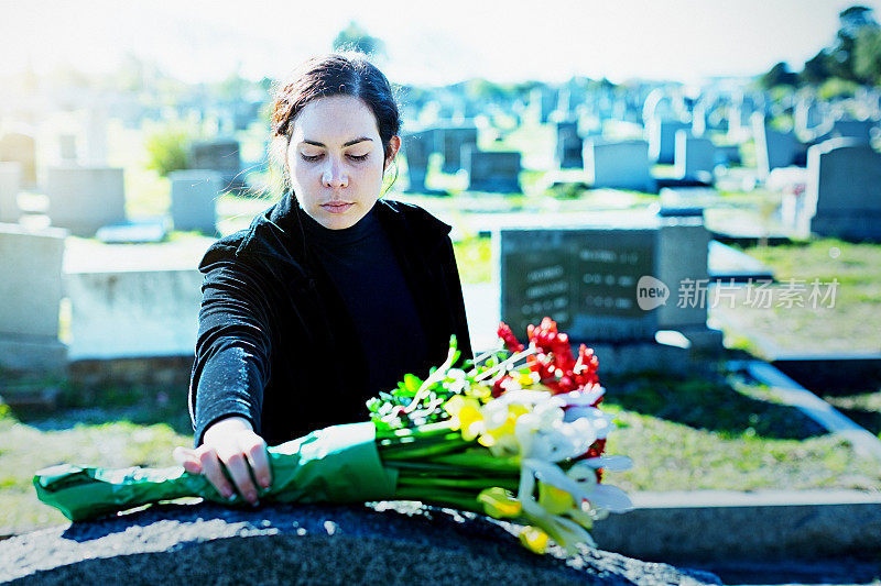 哀悼的妇女在墓地墓前摆放鲜花