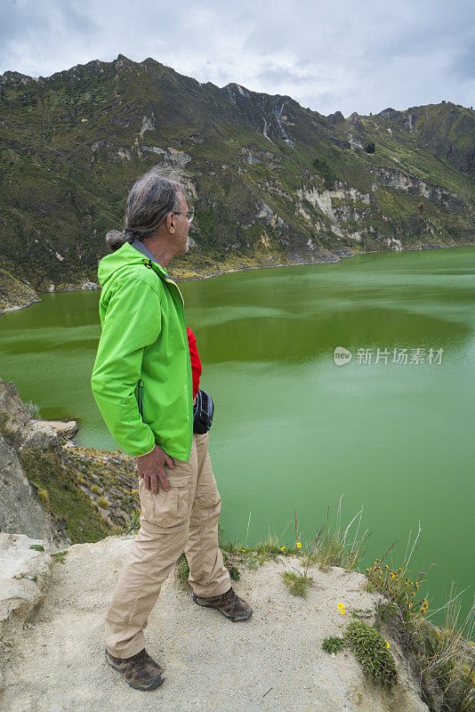 基洛托阿火山上方的岩石上的资深男子的侧视图