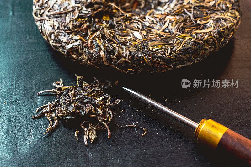 压陈年普洱茶饼和茶道用茶刀。