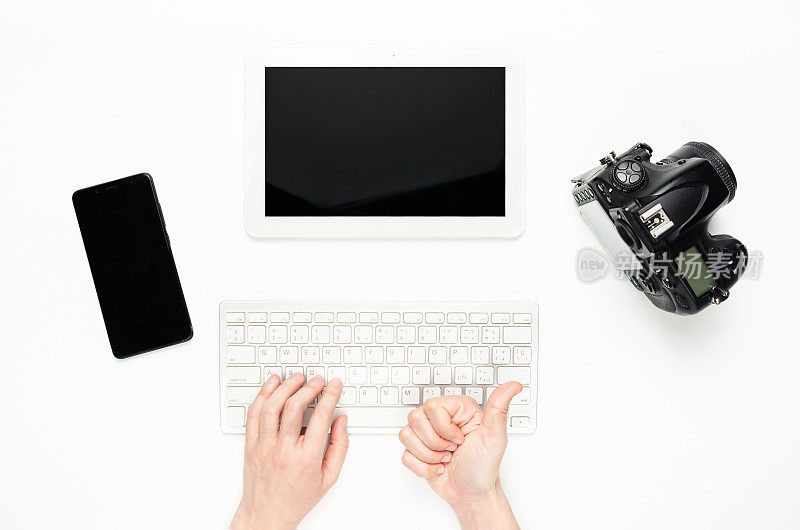 女人的手在用键盘，竖起大拇指。科技产品，平板电脑，相机，智能手机