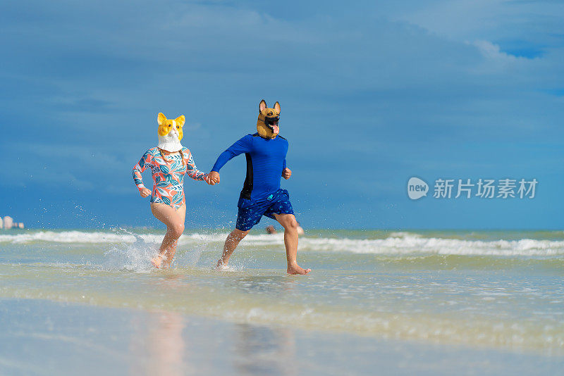 一对戴着动物面具的年轻夫妇在海滩上跑步