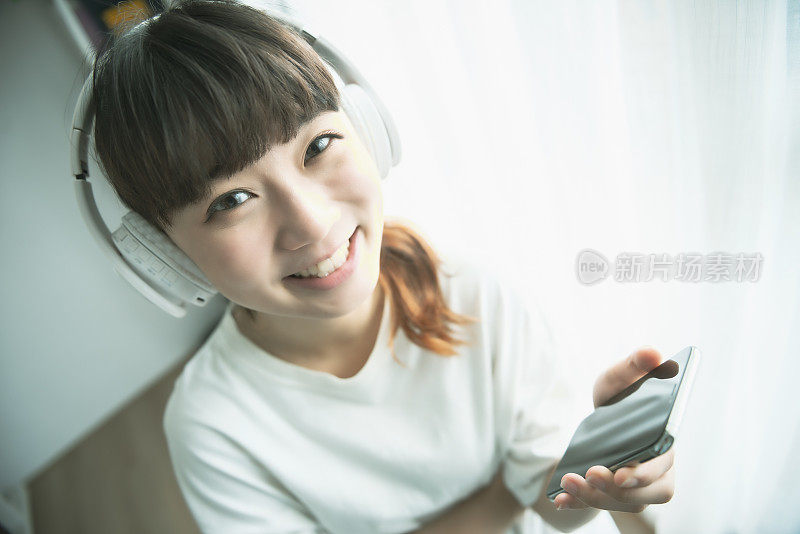 亚洲女性用智能手机听音乐
