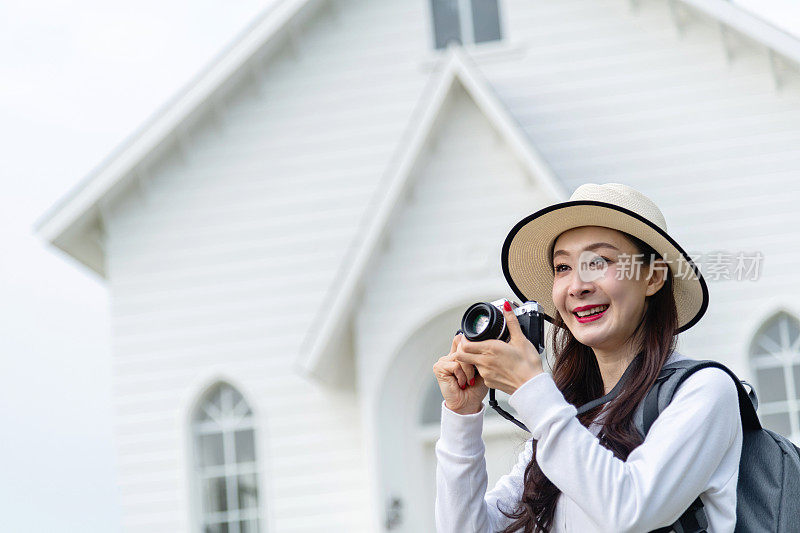 一个女人在小屋前拍照