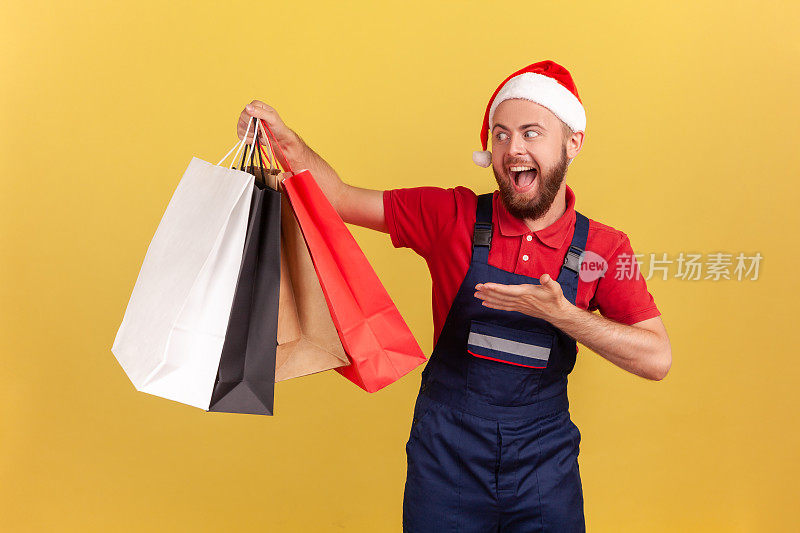 惊喜兴奋的快递员身着蓝色制服，戴着圣诞老人帽展示纸袋，快递从商店发货