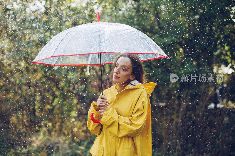 快乐的女人在雨中行走