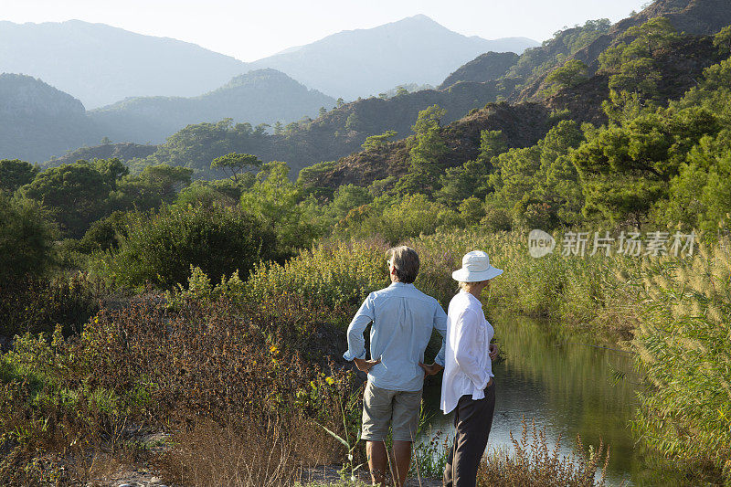 清晨，一对徒步情侣在茂密的森林里放松