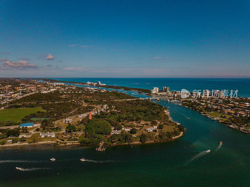 在佛罗里达州朱庇特海滩上的朱庇特灯塔在蓝绿色海水上移动的船只的周末鸟瞰图，在2021年1月的中午