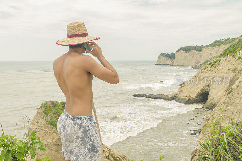 一个拉丁美洲壮汉在海滩上打电话。