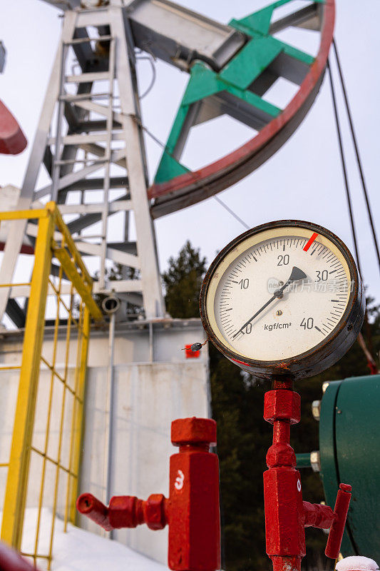 俄罗斯管道压力计油压表显示0(最大25巴-红线)。石油pumpjack。抽油机是油井中往复活塞泵的地上驱动装置。