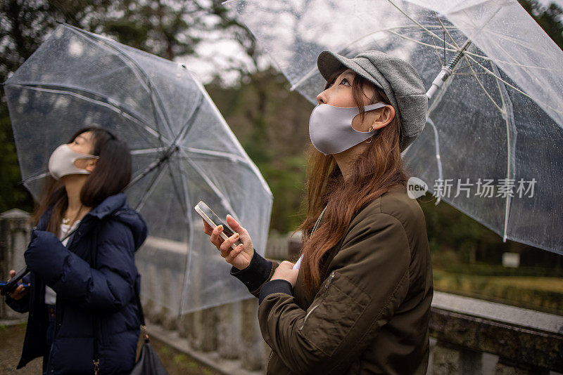 年轻女子戴着防护面罩在雨天远足