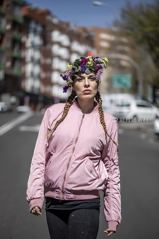 一个三十多岁的女人走在街上，头上戴着花。