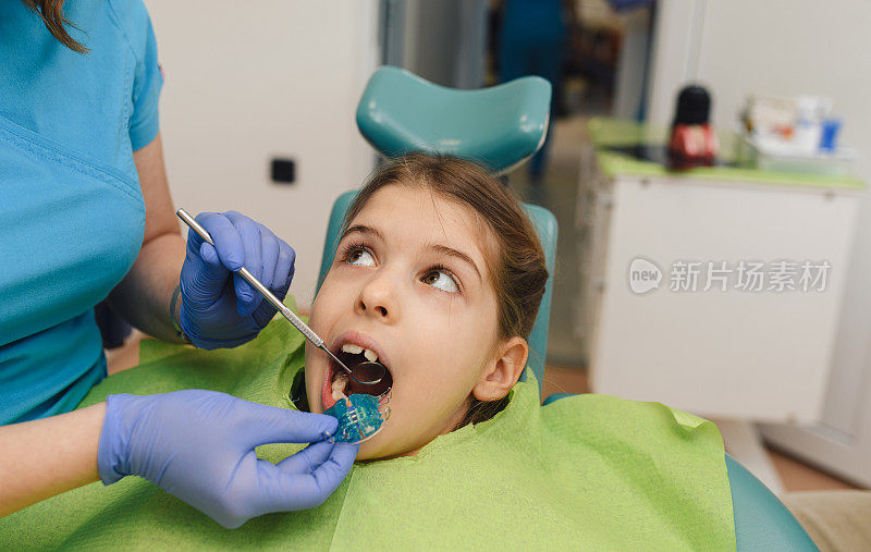 牙医正在给小女孩装牙齿矫正可移动支架。