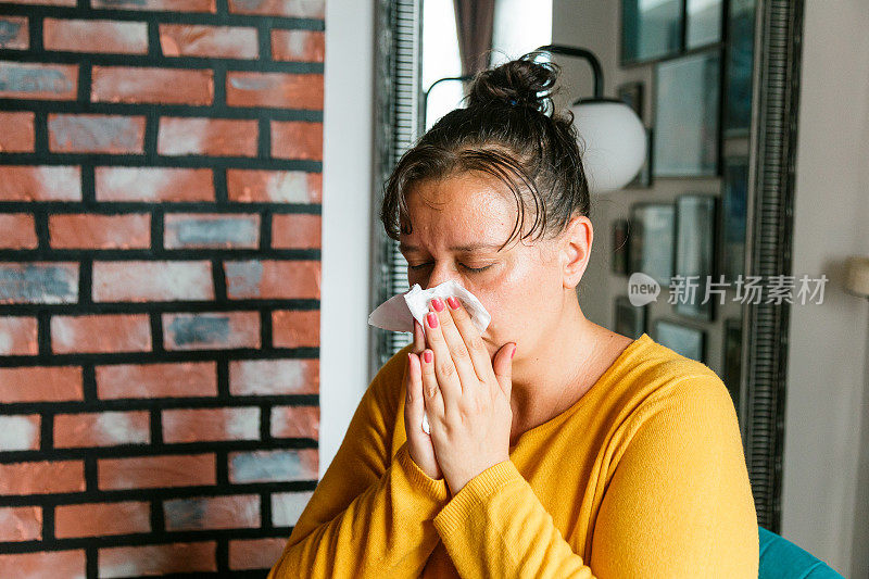 不适妇女在家庭环境中对着纸巾打喷嚏