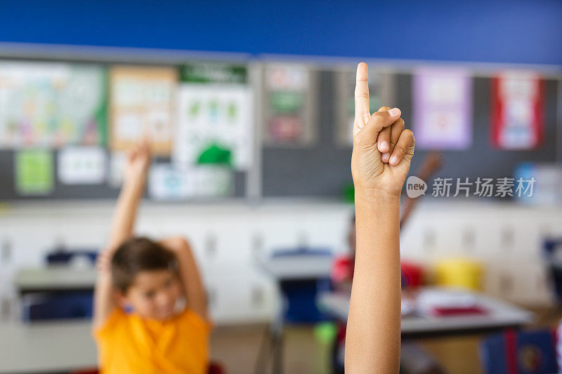 在小学课堂上，一个男孩举手表示愿意参与