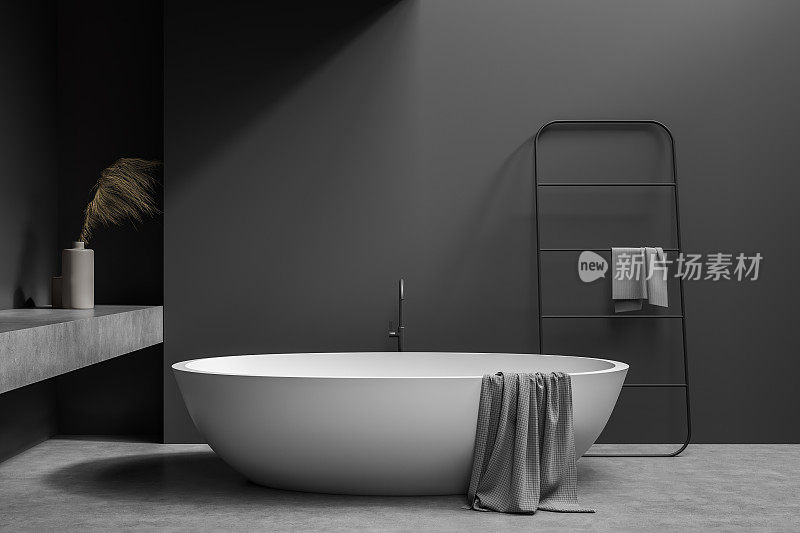 深灰色浴室，椭圆形白色陶瓷浴缸挂衣架