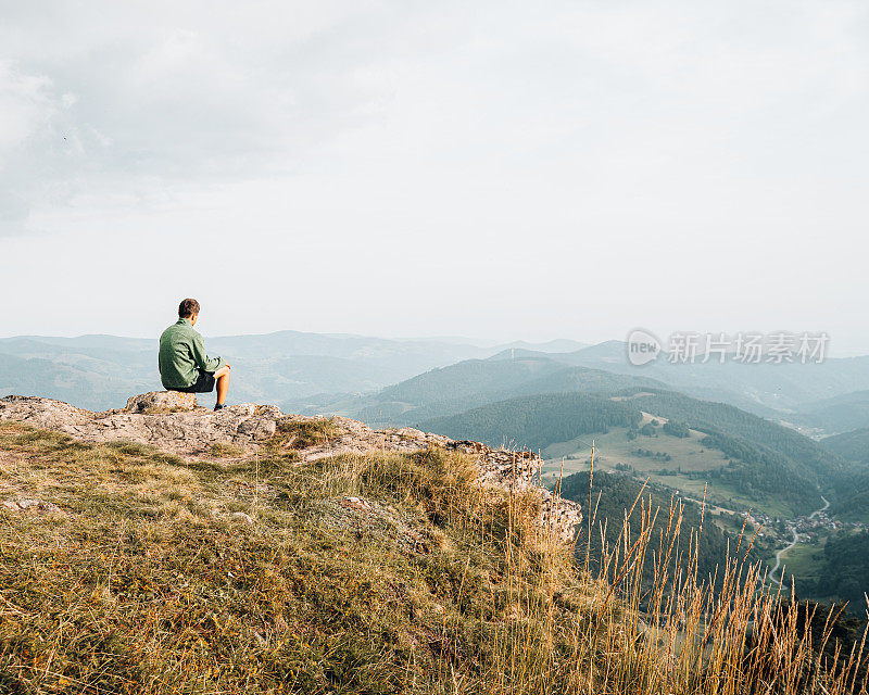 徒步旅行者在长满草的山脊上放松的观点