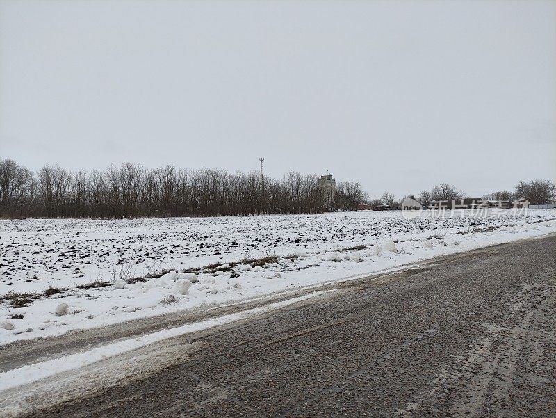 农田里的雪和肮脏的乡村道路