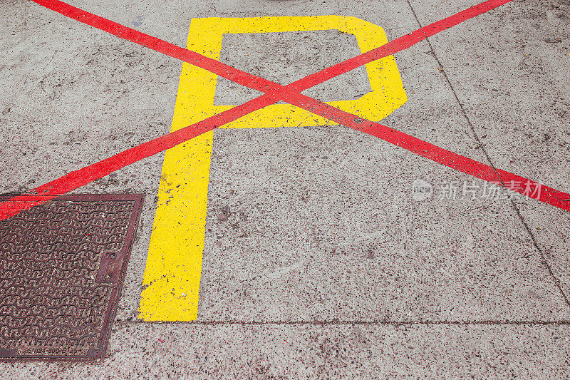 沥青路面上的黄色字母P被红线划掉了，禁止停车