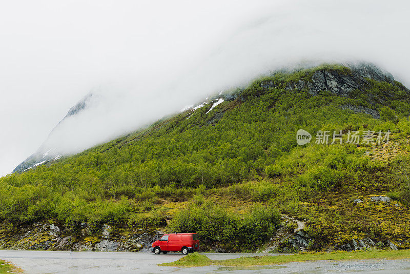 穿过挪威的山路的红色露营车