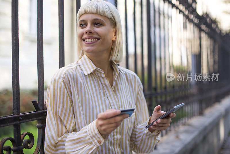 一位女士用她的信用卡在网上购买库存照片