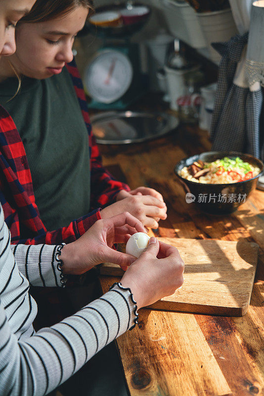 青少年在家庭厨房准备煮蛋牛肉拉面