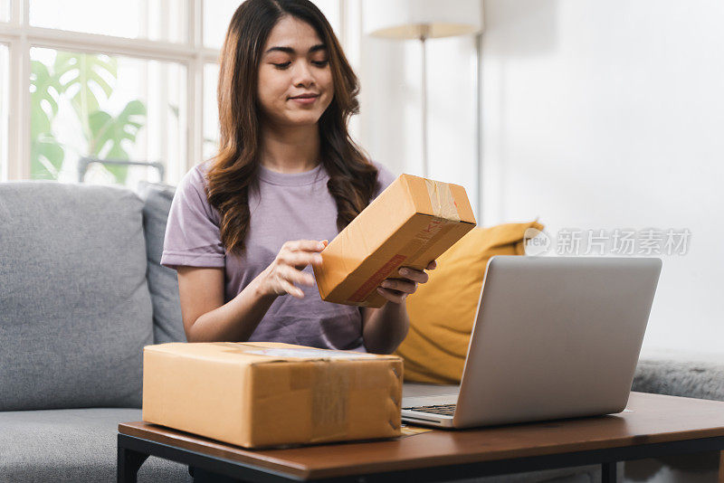 网上购物，年轻的亚洲女性在家接收包裹，并提供送货上门服务。