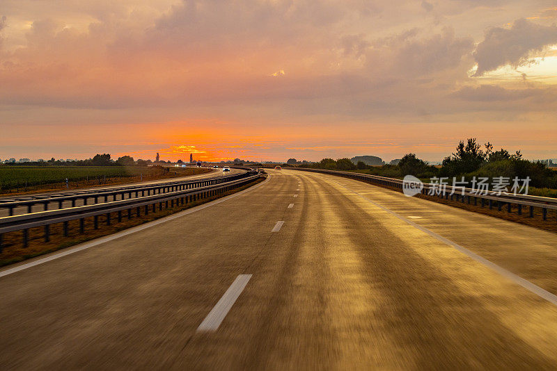 黄昏时在高速公路上逆天行驶的汽车