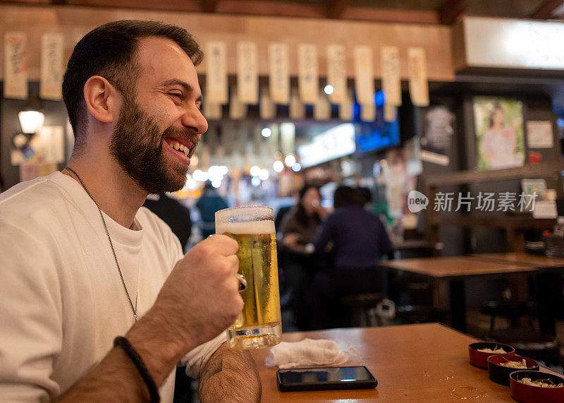 外国游客在日本居酒屋酒吧喝啤酒