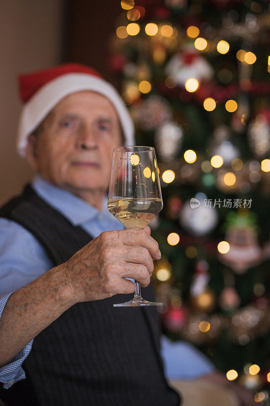 成年男子在家里喝香槟时戴着圣诞老人的帽子