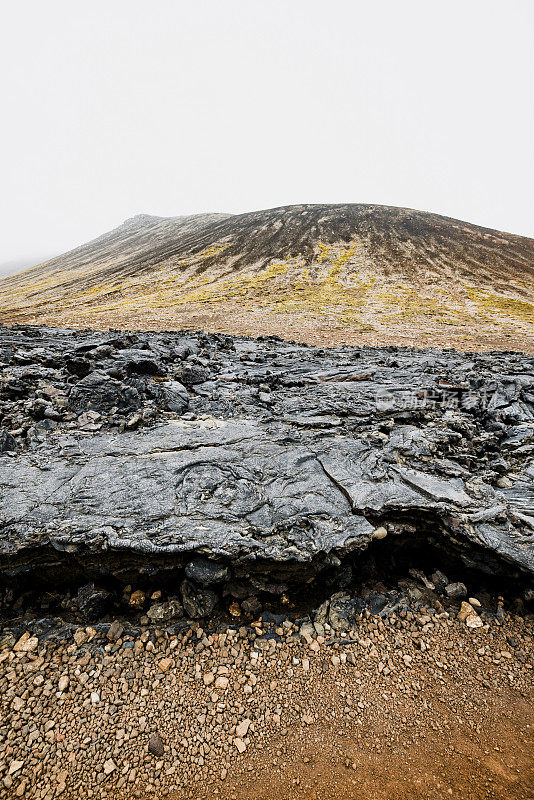 冰岛火山地面的垂直照片，黑色火山岩和红色土壤